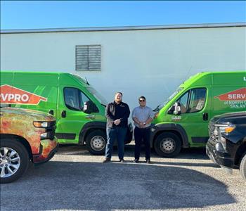 Two men standing in front of a SERVPRO truck